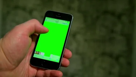 A man holding smartphone with green screen in the evening. 스톡 동영상 70416582