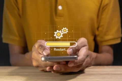 Man holding a smartphone with operating system being restarted or rebooted Stock Photos