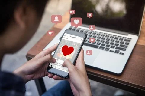 Man holding smartphone using mobile application for instagram on the screen. Stock Photos