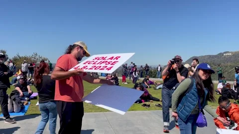 Man Holding Solar Eclipse Sign At Griffith Observatory in Los Angeles Stock Footage 271312965