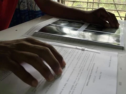 A man holding a sonography report on the table with a window in the background Stock Photos