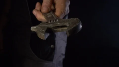Man Holding Spanner In A Dark Room Close Up To Camera Stock Footage 123710401