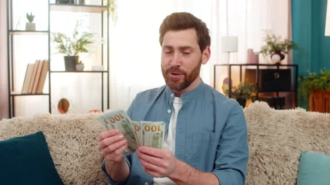 Man holding stack of dollar cash banknotes counting money smiling feeling happy Stock Footage 347028833