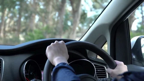 Man holding steering wheel with his hands driving and enjoying new car in the Stock-Footage 336266065