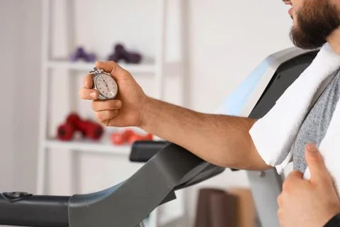 Man holding a stopwatch while exercising on a treadmill, fitness and time man Stock Photos