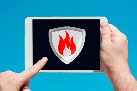 Man holding a tablet device pointing at an anti-spam, security firewall icon Stock Photos