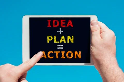Man holding a tablet device with text idea plan action on the screen Stock Photos