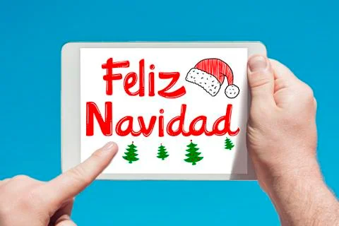 Man holding a tablet device with text in Spanish "Feliz Navidad (Merry Christ Stock Photos