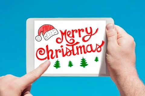 Man holding a tablet device  with text "Merry Christmas" and touching the scr Stock Photos