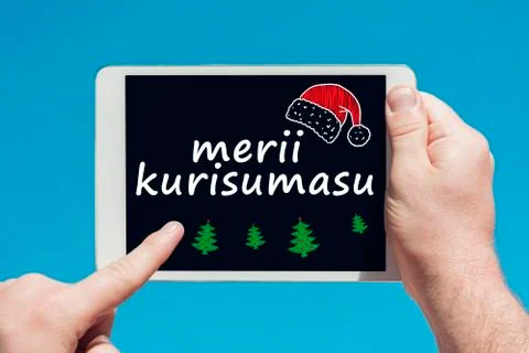 Man holding a tablet device with text in japanese "Merry Christmas" Stock Photos