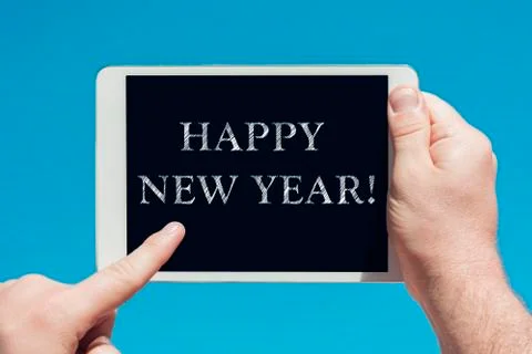 Man holding a tablet device with text "Happy new year" Stock Photos