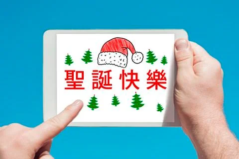 Man holding a tablet device  with text in chinese "Merry Christmas" and touch Stock Photos