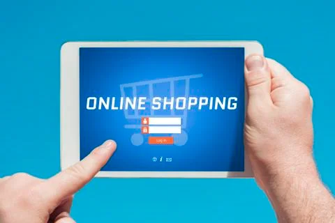 Man holding a tablet device visiting an online shopping website Stock Photos