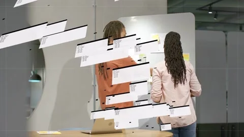 Man holding tablet gesturing at board, woman moving sticky notes for planning, Stock Footage 333078092