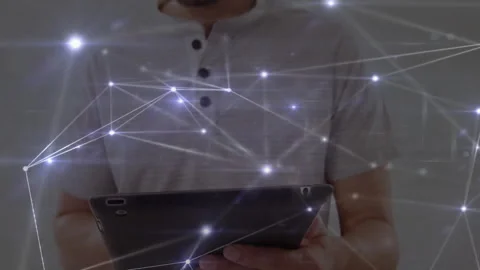 Man holding tablet interacting with digital network overlay in tech office, Stock Footage 307466870