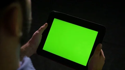 Man holding tablet pc with green screen on black background Stock Footage 74356036