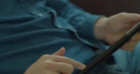 Man holding a TabletPC in hands and typing on its screen while chatting in the Stock Footage 130239016