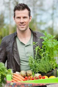 Man holding a tray of raw vegetables Stock Photos