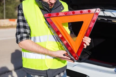 A man holding a triangular sign of an accident Stock Photos