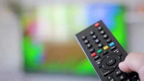 Man holding TV remote control in hand and change channels Stock Footage 131373980