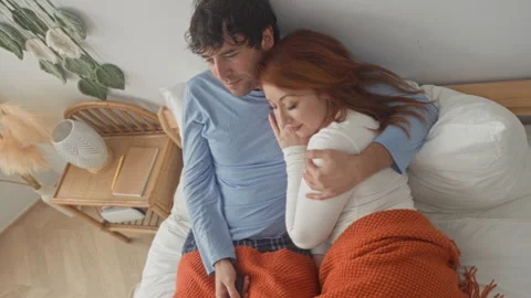 Man holding tv remote while embracing woman on bed in a bedroom inside a bu.. Stock Footage 337393250