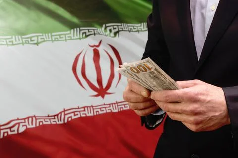 Man holding US dollars in front of the Iranian flag Stock-Fotos