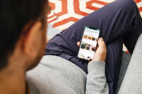 Man holding using the Tripadvisor app on the new Apple iPhone X 10 Display Foto stock