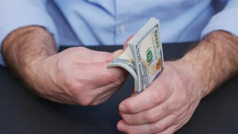 A man holding a wad of dollars in his hand. Stock Footage 146238332