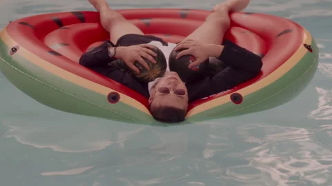 Man holding watermelons as breasts in the pool 스톡 동영상 258321796