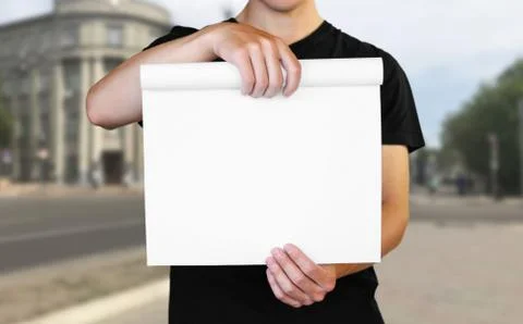 A man holding a white sheet of paper. Holding a booklet. Close up. The backgr Foto stock