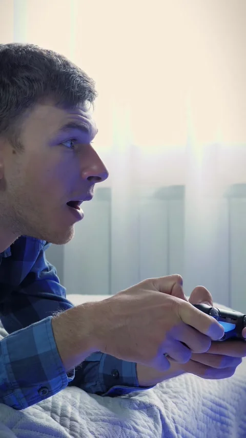Man holding wireless controller, pressing buttons, playing game. Vertical video Stock Footage 330134046