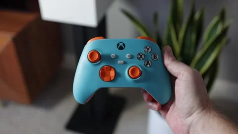 Man holding Xbox gaming controller in modern living room Stock Footage 265470383