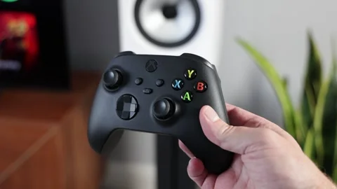 Man holding Xbox gaming controller in modern living room Stock Footage 265470399