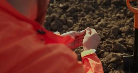 A man holds an ancient coin in his hands, found on a field with a metal detector Stock Footage 272319341