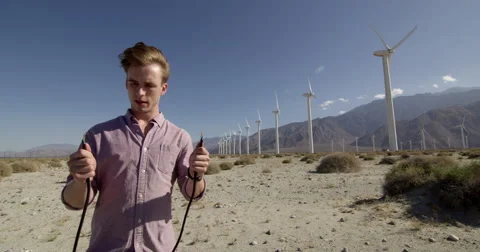 Man holds arcing electric cables at wind farm 4K Stock Footage 63838380