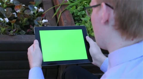 Man holds a blank digital tablet computer with a green screen 動画素材 68056968