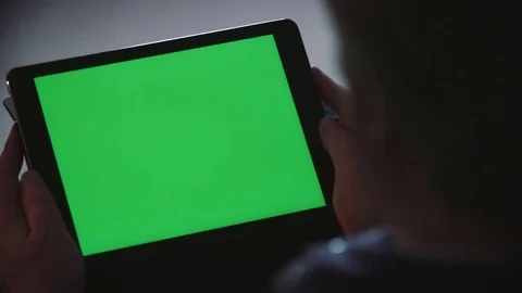 Man holds blank green screen tablet in landscape at home 2 Stock Footage