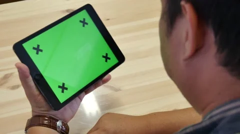A man holds a blank tablet PC with a green screen for your own custom content. Stockbeeldmateriaal 62835677