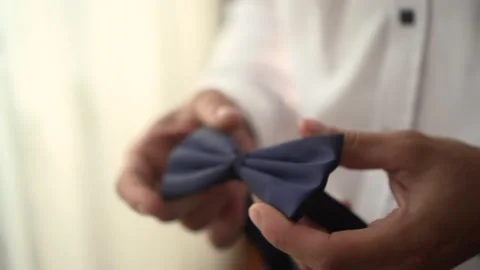 A man holds a bow tie in his hands Stock Footage 166921285