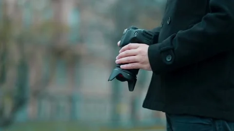 A man holds a camera in his hands, looks at the camera settings. Stock Footage 131368389