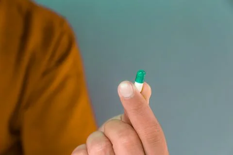 Man holds a capsule Stock Photos