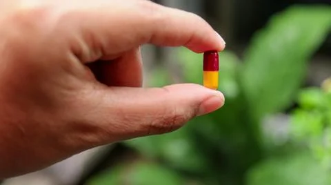 Man holds capsule Stock Photos