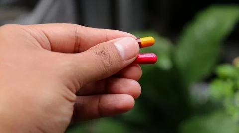 Man holds a capsule Stock Photos