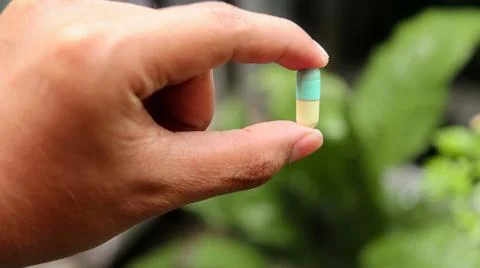 Man holds a capsule Stock Photos