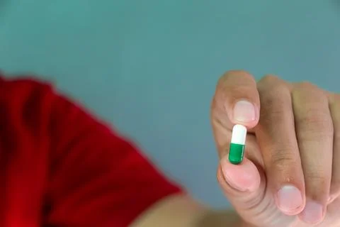 Man holds capsule Stock Photos