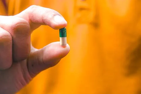 Man holds a capsule Stock Photos