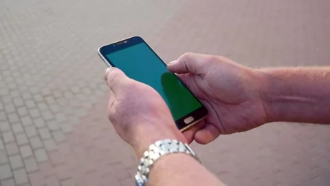 Man holds a Chroma Key green screen smartphone hand and talks about a video call Stock Footage 202019968