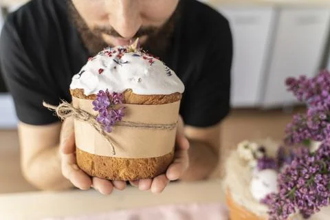 Man holds close-up of an Easter cake in his hands. Traditional pastries for Stock Photos