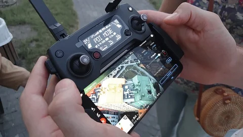 A man holds a drone control panel with a smartphone in his hands Stock Footage 125902392