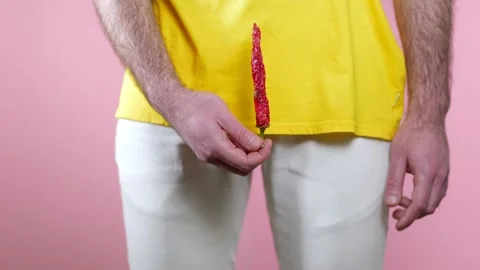 Man holds a dry pepper at the level of genitals which stands up and hangs down Stock Footage 146974585